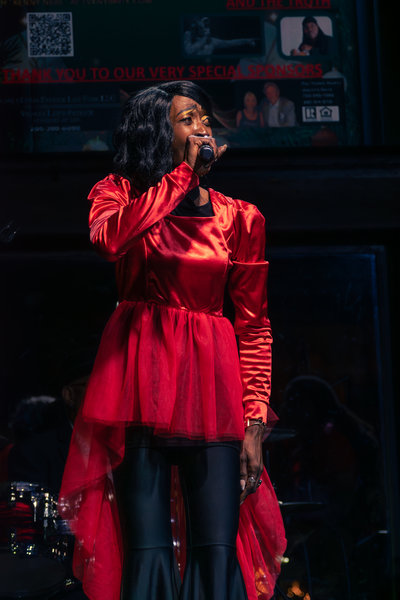 Singer at microphone bathed in red stage light